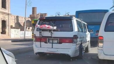طفل مُكفن معلق بظهر الميكروباص